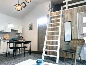 a living room with a staircase and a table and chairs at Domki na Łące in Sarbinowo +19 photos
