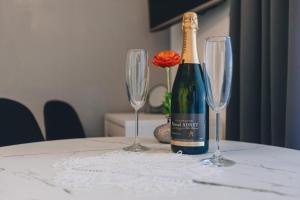 eine Flasche Wein und zwei Weingläser auf einem Tisch in der Unterkunft Luxury Studio Rim Tim in Malinska