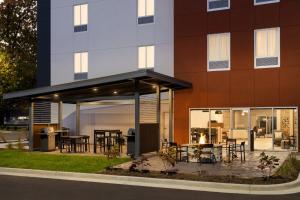 a building with a patio in front of a building at Candlewood Suites Coralville - Iowa City by IHG in Coralville