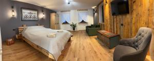 a bedroom with a large bed and two chairs at Daheim in Râşnov