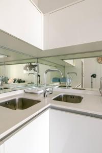 a kitchen with two sinks and white cabinets at Shapz at Ellipse-Waterfall in Midrand
