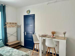 a room with a table and chairs and a blue door at Studio près de la Gare et Centre in Lorient