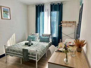 a small room with a bed and a table at Studio près de la Gare et Centre in Lorient
