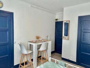 a room with a table and two chairs and a blue door at Studio près de la Gare et Centre in Lorient +13 photos