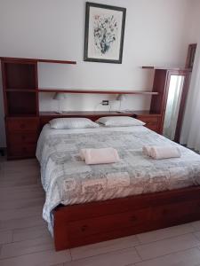 a bedroom with a large bed with two pink pillows at Villa Rho a 5min dalla fiera busness&culture in Rho