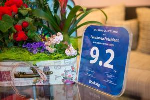 een bord op een tafel met een pot bloemen bij Pensiunea President in Deva