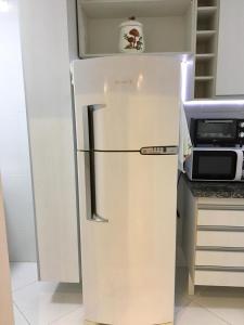 a white refrigerator in a kitchen next to a microwave at Amenity at the Best of Aracaju 2 Beds in Aracaju