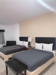a bedroom with two beds and a bench in it at Hotel Marina Topolobampo in Topolobampo +44 photos