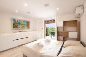 a bedroom with two beds and a tv on the wall at Mazet design vue mer 4 guests in Sainte-Maxime +9 photos