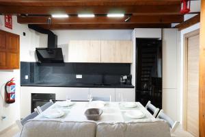 a kitchen with a white table with chairs and a kitchen at Preciosa casa en el Albaicín in Granada