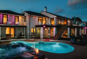 a large house with a swimming pool in front of it at Heron House in Newquay