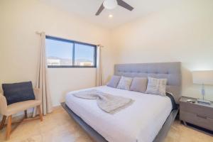 a bedroom with a bed and a chair and a window at Oceanview condo w Resort amenities Steps to Beach in El Sargento +27 photos