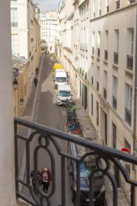 a view from a balcony of a city street with cars at Ômarais Guest House in Paris
