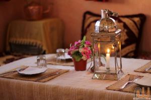 Hotel Cascades Dades في Aït Ben Ali: طاولة عليها شمعة ومصباح زجاجي
