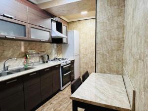 a kitchen with a sink and a table and a kitchen with a stove at Awesome Brilliant Apartment in City Center with 2 bedrooms in Yerevan