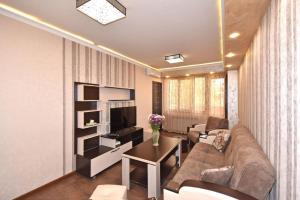 a living room with a couch and a tv at Awesome Brilliant Apartment in City Center with 2 bedrooms in Yerevan