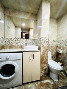a bathroom with a washing machine and a toilet at Awesome Brilliant Apartment in City Center with 2 bedrooms in Yerevan +19 photos