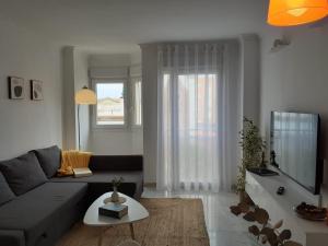 a living room with a couch and a table at Apartamento Los Naranjos in La Línea de la Concepción