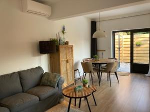 a living room with a couch and a table at Noordster Beachhouse, Noordwijk aan Zee in Noordwijk