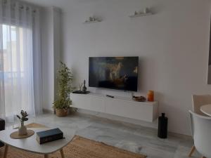 a living room with a tv on a white wall at Apartamento Los Naranjos in La Línea de la Concepción