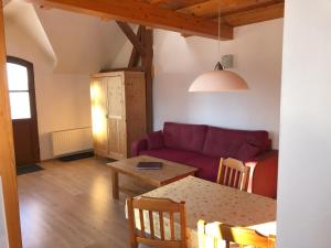 a living room with a red couch and a table at Braunsberger Höfe - Urlaub auf dem Bauernhof in Braunsberg