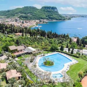 una vista aerea di una villa con piscina e lago di Dani's Lakeside Apartment in Euroresidence a Garda