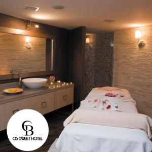 een badkamer met 2 bedden, een wastafel en een spiegel bij CB Sweet Hotel in Baku