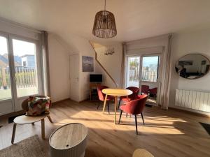 ein Wohnzimmer mit Tisch und Stühlen in der Unterkunft Maison rénovée à Agon-coutainville proche de la mer, classé meublé de tourisme 3 étoiles in Agon Coutainville