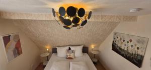 une chambre avec un lit et un lustre dans l'établissement Nordic Vintage Cottage - ComfyHome Apartments Stuttgart, à Stuttgart