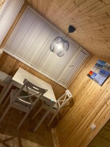 a room with a table and a chair and a lamp at Dārza māja in Liepāja