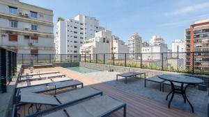 un patio con tavoli e panche su un edificio di DH: Alto Pinheiros: Luxo e Exclusividade com vista Panorâmica. a San Paolo