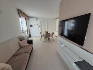 a living room with a couch and a flat screen tv at Sole di Puglia in Putignano