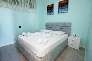 una camera da letto con un letto con asciugamani bianchi sopra di emBrace Apartments a Sarandë