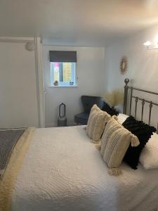 Un dormitorio con una cama con almohadas y una ventana. en Studio 114, en Isle of Wight