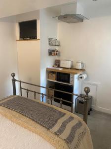 1 dormitorio con 1 cama, escritorio y TV en Studio 114, en Isle of Wight