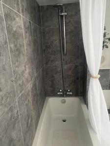 Un baño con bañera y cortina de ducha. en Studio 114, en Isle of Wight