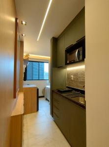 a kitchen with a stove and a microwave at Apartamento charmoso com Rooftop in Salvador
