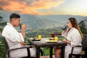 a man and a woman sitting at a table eating food at Amore Mio Glamping in Jenesano