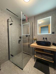a bathroom with a glass shower and a sink at Modern Alpine Apartment Corso Harrachov in Harrachov