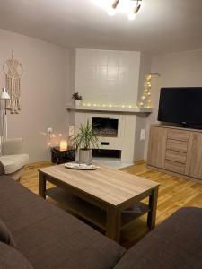 a living room with a coffee table and a fireplace at Dārza māja in Liepāja