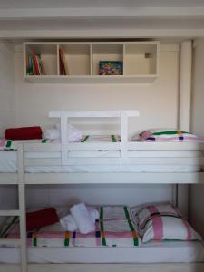 2 Etagenbetten in einem weißen Zimmer mit in der Unterkunft Vakantiewoning voor het gezin in Stavenisse in Stavenisse