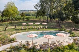 SantʼAndrea in CasaleVilla Yeppa的配有椅子和遮阳伞的游泳池