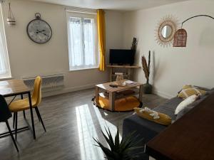 a living room with a couch and a table at Gîte des hallettes in Fécamp