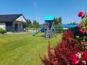 a playground with a slide in a yard at Błękitna Laguna 600m od morza in Rusinowo