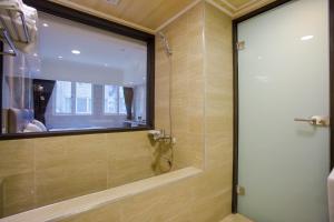 y baño con ducha y puerta de cristal. en Shui Sha Lian Hotel en Yuchi