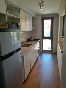 a kitchen with a refrigerator and a wooden floor at Carocito Departamento in San Carlos de Bariloche