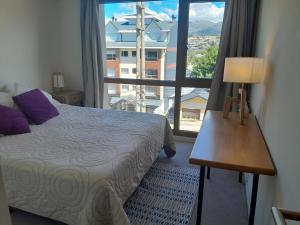 a bedroom with a bed and a large window at Carocito Departamento in San Carlos de Bariloche