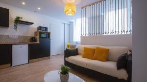a living room with a couch and a kitchen at LE PETIT PRINCE du DESERT in Moissac