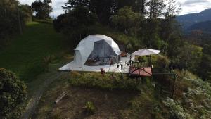 a white tent on the side of a hill at Amore Mio Glamping in Jenesano