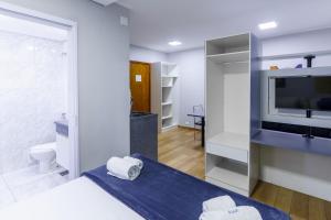 a bedroom with a bed and a tv and a bathroom at Carillon Plaza Hotel in São Paulo